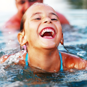 Young girl laughing in a swimming pool